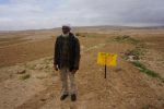 Hilayel Abu Jlidan in his field that was ploughed by the ILA near a sign stating 