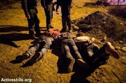 שלושה מן העצורים בהפגנה אזוקים עם פניהם לרצפה. צילום: אקטיבטילס